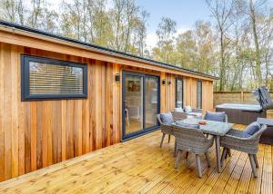 ein Haus mit einem Tisch und Stühlen auf einer Terrasse in der Unterkunft Elton Furze Retreats in Haddon + 17 Fotos