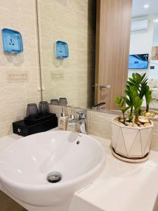 un baño con lavabo blanco y una planta en una encimera en Lily'house - Apartment Vinsmart City Tây Mỗ, en Kon Rung (1)