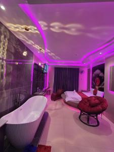 a bedroom with a tub and a bed with purple lighting at Khách Sạn Hoa Vinh - Thủ Đức in Ho Chi Minh City