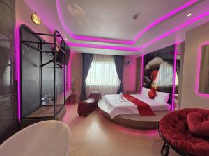 a bedroom with a bed with a pink lighting at Khách Sạn Hoa Vinh - Thủ Đức in Ho Chi Minh City