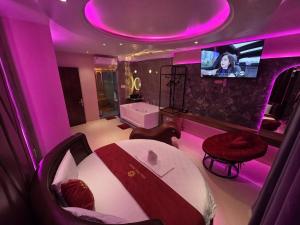 a purple room with a bed and a tv at Khách Sạn Hoa Vinh - Thủ Đức in Ho Chi Minh City