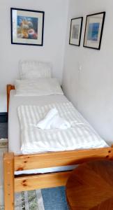 a bed with a wooden frame in a room at Tripplezimmer mit Garten, Kicker und Grill in Berlin