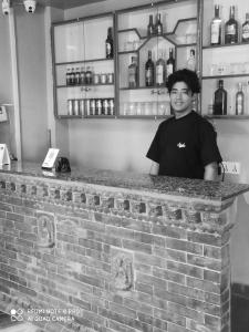 a man standing behind a counter in a bar at Hotel namo buddha in Sauraha