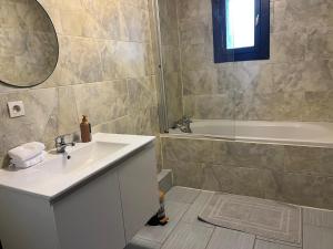 un bagno con lavandino e vasca da bagno di Charmant studio avec terrasse a Aiguebelle