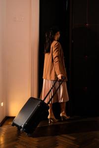 a woman walking into a door with a suitcase at Buxbaum Beletage Design & Boutique Hotel in Vienna