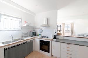 a kitchen with a sink and a stove top oven at Verde Blu Scirocco Lake Front Apartment Trevignano Romano in Rome