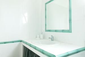 a white bathroom with a sink and a mirror at Verde Blu Scirocco Lake Front Apartment Trevignano Romano in Rome