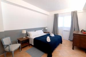 a bedroom with a bed and a chair and a window at Verde Blu Scirocco Lake Front Apartment Trevignano Romano in Rome