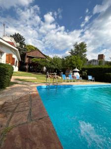 a swimming pool with blue chairs in a yard at Casa - Chalet Valle del Reposo in Bialet Massé