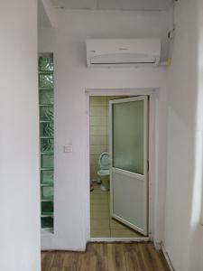 un bagno vuoto con servizi igienici e porta di Casa Avocaților a Corabia