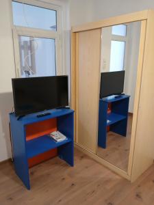 uno specchio in una stanza con una TV e un mobile blu di Casa Avocaților a Corabia