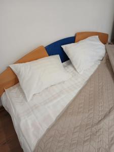 un letto con lenzuola bianche e cuscini sopra di Casa Avocaților a Corabia Altre 9 foto