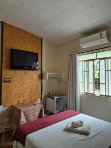 Una habitación de hotel con una cama y un televisor en la pared. en Hotel Pousada Casa Verde, en Cordisburgo 45 fotos más