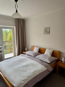 Vila Nezábudka 206, Tatranská Štrba في تاترانسكا ستربا: غرفة نوم بها سريرين ونافذة