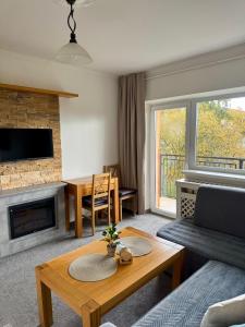 Vila Nezábudka 206, Tatranská Štrba في تاترانسكا ستربا: غرفة معيشة مع أريكة ومدفأة