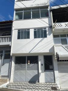 una casa blanca con puertas y ventanas en Ao lado do Hospital Calixto excelente localização, en Itabuna