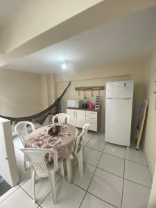 Una cocina con mesa y sillas y un refrigerador. en Ao lado do Hospital Calixto excelente localização, en Itabuna