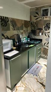 una cocina con fregadero y microondas en Casas de Temporada Rua da Aurora em Praia do Forte Bahia, en Mata de Sao Joao