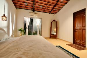 a bedroom with a large bed and a window at NOSSA GOA VILLA in MUMBAI GORAI in Mumbai +24 photos