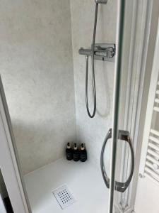 a shower with three pairs of shoes in a bathroom at Centre Nemours - Climatisation - Cosy Deluxe in Nemours +15 photos