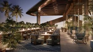 a restaurant with tables and chairs and palm trees at Mandarin Oriental Downtown, Dubai in Dubai