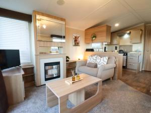 een woonkamer met een bank en een open haard bij Swift Cabin in Staintondale