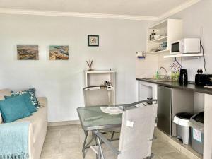 a kitchen and living room with a table and a couch at Southern Blue Agulhas in Agulhas