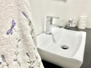 Southern Blue Agulhas في أقولاس: حوض حمام مع منشفة عليها فراشة +36 صورة