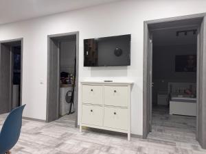 a living room with a tv on a wall at Popoveni Garden Vila in Craiova