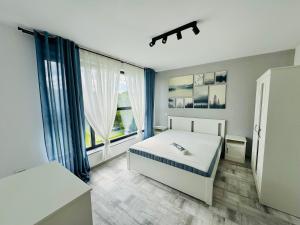 a bedroom with a bed and a large window at Popoveni Garden Vila in Craiova