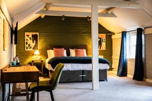 a bedroom with a bed and a desk and a chair at The Red Lion in Thames Ditton