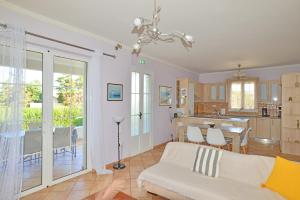 a living room with a white couch and a kitchen at Tzitzi Pistachio Villa in Khlóï