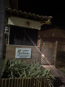 a building with a sign in front of a yard at Charmoso dúplex canto do jandaia in Mata de Sao Joao +3 photos