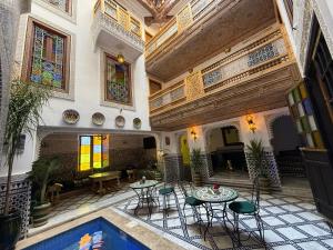 Un patio interior con mesas y sillas y una piscina. en Riad Dar El bellar, en Fez