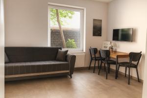 Livemore24 - Apartment 2 in Herten 24-7 Check-In في هيرتين: غرفة معيشة بها أريكة وطاولة ونافذة