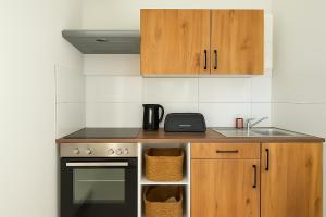 Livemore24 - Apartment 2 in Herten 24-7 Check-In في هيرتين: مطبخ مع حوض وموقد ودواليب