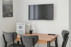 Livemore24 - Apartment 2 in Herten 24-7 Check-In في هيرتين: طاولة وكراسي وتلفزيون على جدار +4 صور