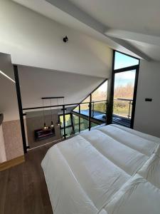 Un dormitorio con una gran cama blanca y una chimenea. en Malena Lux, en Čačak