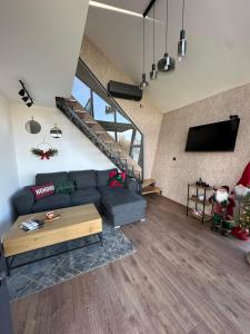 Una sala de estar con un sofá y una escalera. en Malena Lux, en Čačak