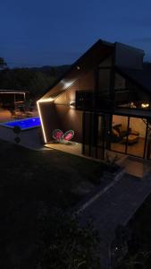 una casa con dos sillas delante de ella por la noche en Malena Lux, en Čačak 6 fotos más