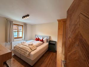 a bedroom with a bed with red pillows and a window at Kitzbühel Garten Suite in Kitzbühel