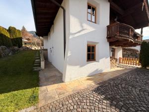 a white house with a balcony on the side of it at Kitzbühel Garten Suite in Kitzbühel
