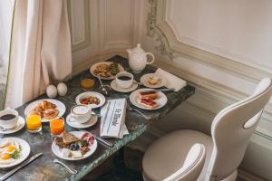 a breakfast table with plates of food on it at Hôtel Régent Contades By Stay Collection in Strasbourg
