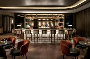 a bar in a restaurant with bar stools at Radisson Blu Hotel, Almaty Airport in Almaty