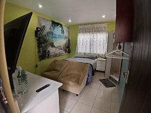 a small bedroom with a bed and a chair at Gaia Hydro-Spa and Guest House in Cape Town
