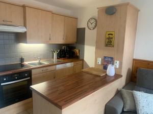 a kitchen with a wooden counter top and a sink at Très bel appartement pied de pistes 6 pers Serre Chevalier Chantemerle in Saint-Chaffrey