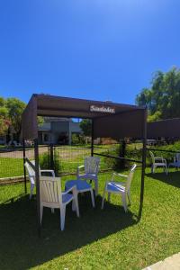 a gazebo with chairs and tables in the grass at Complejo STC SomoS in Colón