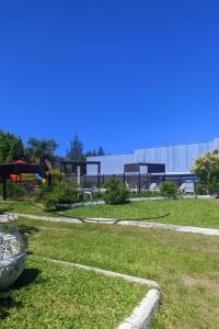a field of grass with a building in the background at Complejo STC SomoS in Colón
