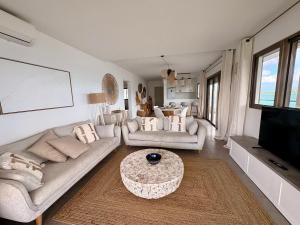 a living room with a couch and a table at Infinity View Beach House, 2 bdr in Baie Nettle