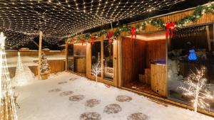een huis bedekt met sneeuw met kerstverlichting bij Rezydencja Delta Boutique in Kościelisko